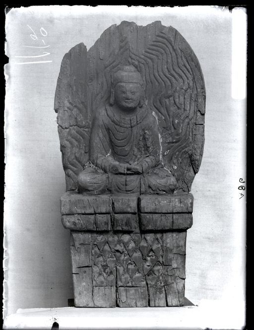 A 86: Skulptur eines sitzenden Buddha auf hohem Thron mit Bergmuster ; Holz mit Wellen-Mandorla