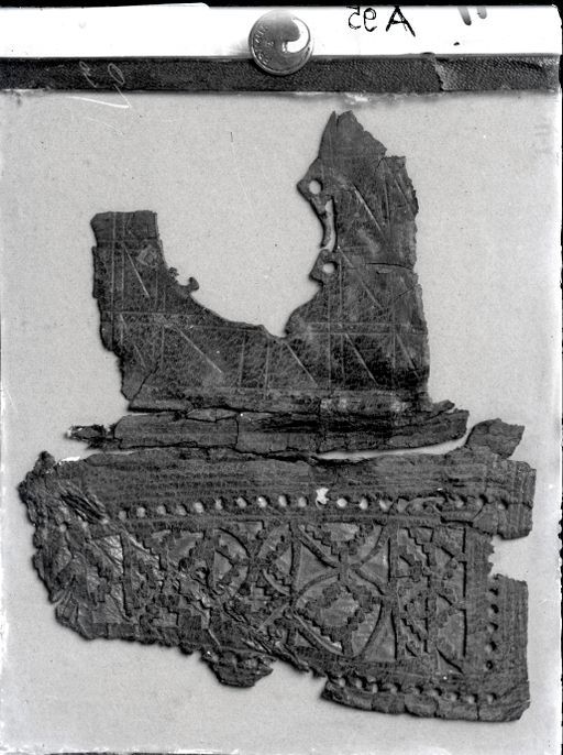 A 95: Fragment eines Buchdeckels ; Braunes Leder mit gestanztem mit Gold unterlegten Ornament, gehörig zu A 103