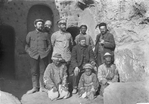 B 1038: Gruppenbild: Die Teilnehmer der 3. Expedition in Kizil vor der Kaminhöhle v.l.n.r stehend: Hermann Pohrt, Theodor Bartus, Albert v. Le Coq, sitzend: Albert Grünwedel und ihre Mitarbeiter