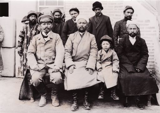 B1071: Theodor Bartus und Isa Khan sowie dessen Söhne; im Hintergrund Bedienstete (Turfan_IV_14_B_1071_blass.jpg)