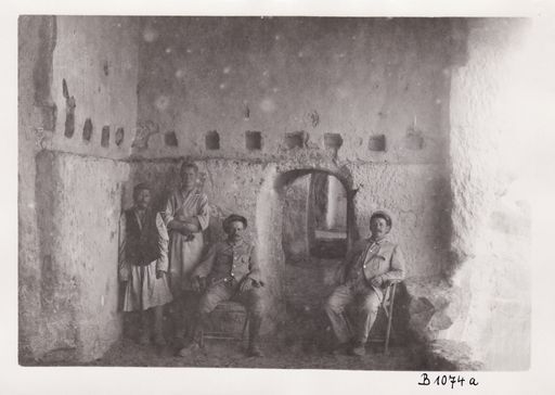 B1074: Albert von Le Coq und Theodor Bartus mit zwei Arbeitern in der Vorhalle zu Höhle 70 (Turfan_III_46_B_1074a_Le_Coq_Bartus_in_Kumtura.jpg)