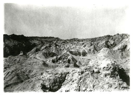 B1168: Panorama einer Hügellandschaft mit Höhlenanlage im westlichen Zentrum des Tals, im Vordergrund eine Stūpa-Ruine (B_1168_pos.jpg)