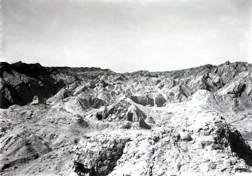 B1168: Panorama einer Hügellandschaft mit Höhlenanlage im westlichen Zentrum des Tals, im Vordergrund eine Stūpa-Ruine (B_1168_Kir_SW.jpg)