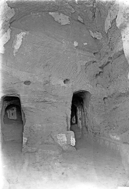 B1218: Innenansicht einer Kulthöhle mit Umwandlungsgang und Malereiresten. Vor dem Zentralpfeiler befindet sich noch ein Sockelrest von einem Standbild (?) (B_1218_Kumx_Kizx.jpg)