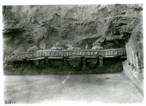 B 1240: Mauerwerk mit Sockel mit Reliefs von Blüten, Perlmustern und Steinzwischeln, darüber Lotos-Sockel