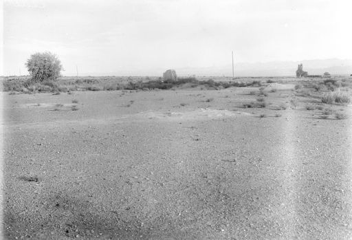 B 1457: Ruinen von Cädir in trockener Landschaft, im Hintergrund ein Bauernhaus.