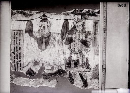 B 146: Sockel einer Praṇidhi-Szene mit Stiftern: in der Mitte ein Mönch der einen Lotos hochhält, auf dem ein Buddha stand, uig. Inschrift