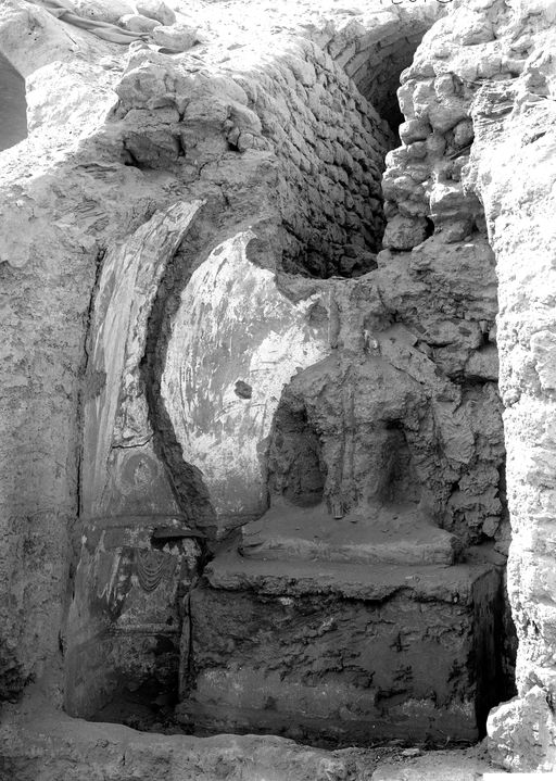 B1634: Lehmplastik einer sitzenden Buddhafigur mit Resten von Wandmalerei in einer kleinen Cella vor einem gemauerten Stollen, der uighurische Manuskripte und künstliche Blumen enthielt. (B_1634_Bez.jpg)