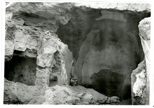 B 1672: Cella einer Höhle mit Tonnengewölbe und Umwandlungsgang, geweißte Verputzreste, links daneben weitere Höhlenanlage. In der linken Seitenwand Durchgang zu Nebenraum. Junge lehnt an der linken Wand.