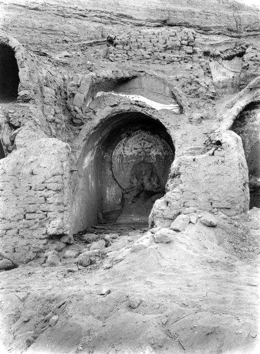 B1675: Gemauerte Cella mit Gewölbe und Resten eines sitzenden Buddha mit großer flammender Mandorla, Reste von Wandmalerei. Die Konstruktion der Zellenreihe mit gemauerten Doppelgewölben gegen den gewachsenen Fels ist gut zusehen. (B_1675_Bez_24.jpg)