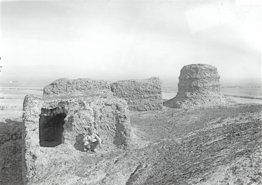 B1704: Ein Junge hockt neben Resten von Bauten und Stūpastumpf auf Hügelkuppe. (B_1704_xxx_Gebaeude.jpg)