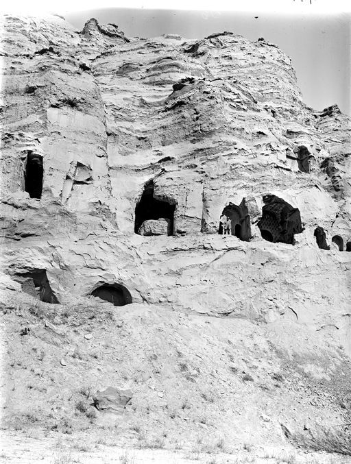 B1714: Höhlen westlich der Teufelshöhlen: Bartus steht in 197, deutlich zu sehen ist die rechte Seitenwand von Teufelshöhle C mit den von Grünwedel beschriebenen Details von Tempel A. ist nur die Zentralnische und der Eingang zum rechten Umwandlungsgang erkennbar. (B_1714_Kiz_198_199.jpg)