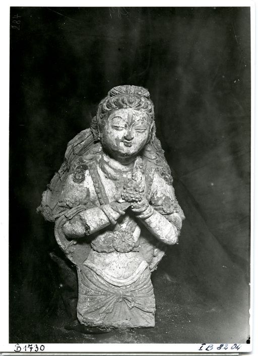 B 1730: Halbfigur einer männlichen Devatā mit Blumen