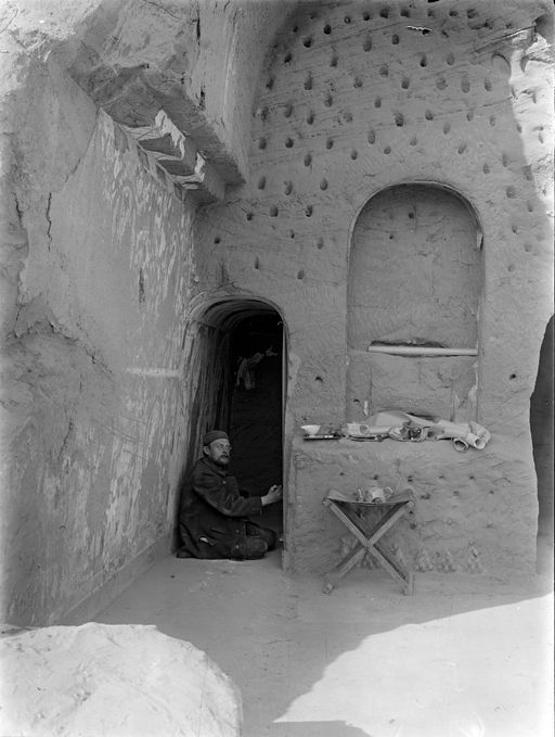 B1739: Grünwedel kopiert Malereien im linken Seitengang. Lehrszenen an der linken Seitenwand, Dübellöcher um die Zentralnische. An den Seitenwänden der Cella sind Lehrszenen zu erkennen (B_1739_Kiz_4_Personen.jpg)