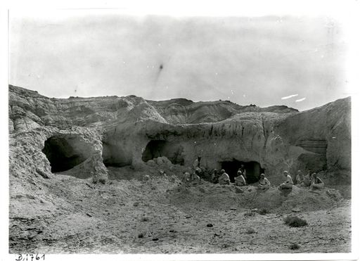 B1761: Le Coq inmitten seiner Arbeiter bei Grabungsarbeiten an den Höhlen im Westen des Tales vor der Höhle mit den charakteristischen Bögen und Rautenmustern. (B_1761_pos.jpg)