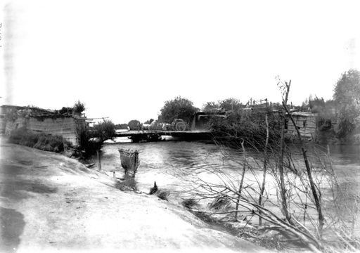 B 1813: Fuhrwerk (Araba) überquert auf schmaler Brücke das Hochwasser eines reißendem Flusses zwischen Hütten.