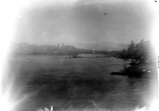 B 1814: Blick von einer Brücke: Hochwasser am Fluss mit Bergen in Hintergrund.
