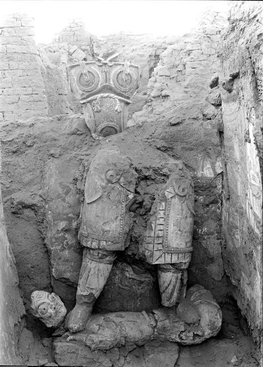 B1823: Gemauerte Cella mit Resten von Wandmalereien und unterem Teil einer Lehmplastik eines Mannes im Waffenrock auf einem Dämon stehend. (B_1823_Gebaeude_Figur.jpg)