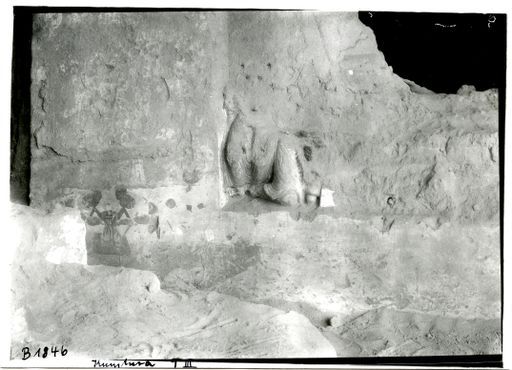 B 1846: Stifter in chinesischer Tracht hält die Füße eines weitgehend verschwundenen Buddha, daneben plastisch gestaltete Lehm-Mönche (?)