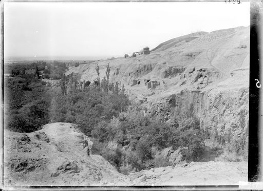 B947: Blick vom östlichen, linken Ufer zur Westseite mit Gebäuderesten und dem Platz des ehemaligen Avalokiteśvara-Heiligtums, das heute eine muslimische Pilgerstätte der Siebenschläfer ist. (B_0947_Toyuk.jpg)