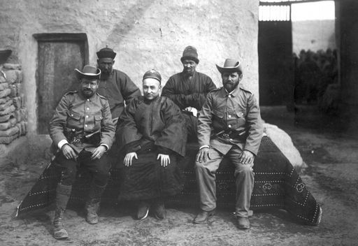 B956: Albert von Le Coq und Theodor Bartus mit Imin Khoja, dem Fürsten (Wang) von Lukchun; hinter ihnen sind Wirt Sa'ut und ein Bedienstete zu sehen. Dies Foto wurde auch als Postkarte verschickt. VS: Textseite der Postkarte (B_0956_T_II_Khocho_mit_Wang_von_Luktschun.jpg)