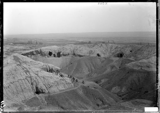 B 968: Panorama eines Hügels mit Höhlenanlagen, Ausgrabung (vorn) im Bereich des sog. Schwellentempels