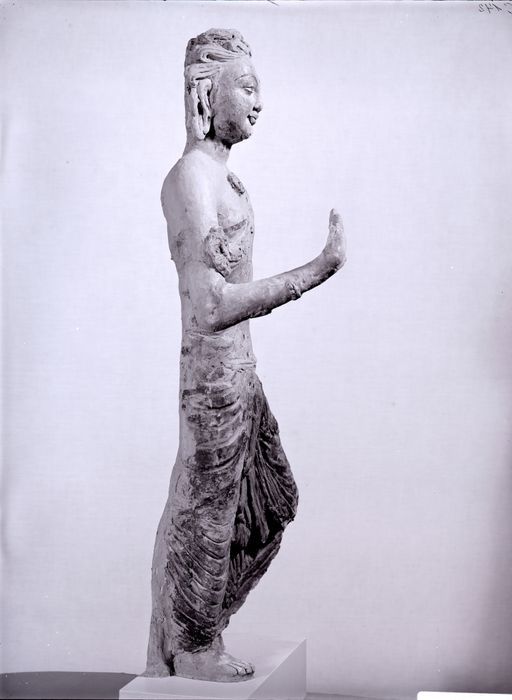 C 145: Devatā (Gottheit), stehendin Abhayamudrā und mit einem angewinkelten Knie, eine antike Maske in der Krone, Seitenansicht