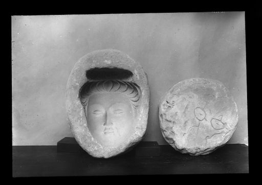 T 421: Links: Model für die Abformung eines Gesichts eines Bodhisattva-oder Devatā-Kopfes; rechts: Rückseite einer nicht dazugehörigen runden Model (Kriegsverlust) mit Einritzung des Namens des Eigentümers der Model: rthat rthat ; Abguss davon s.: III 8252