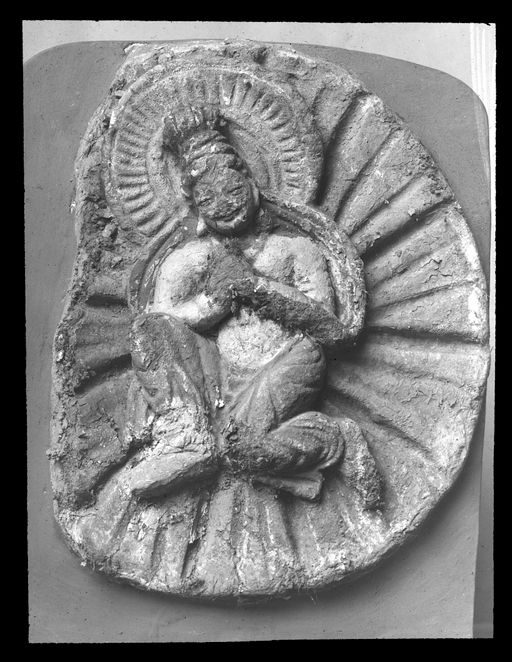 T 442: Anbetende, schwebende Gottheit auf Schmuckscheibe im Strahlenkranz