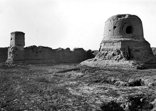 T 473: Blick von Norden auf einen Stūpa (D) in der Südwestecke eines Hofes mit mehreren Stūpas und ein Pfeilertempel jenseits deren südlicher Mauer.