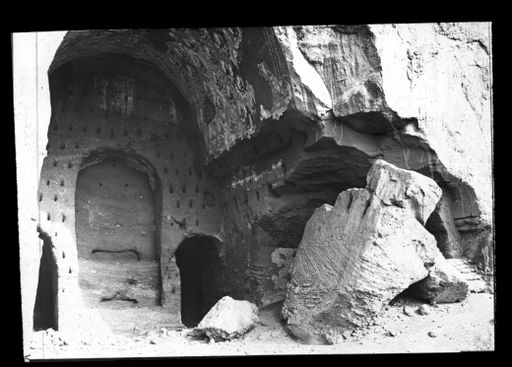 T 504: Zentralpfeilerhöhle mit Dübellöchern für die Befestigung von Lehmapplikationen an der Kultbildwand, um die Nische herum. Ein abgestürzter gewaltiger Felsblock ist zeuge von der schleichenden Zerstörung der Höhlenräume.